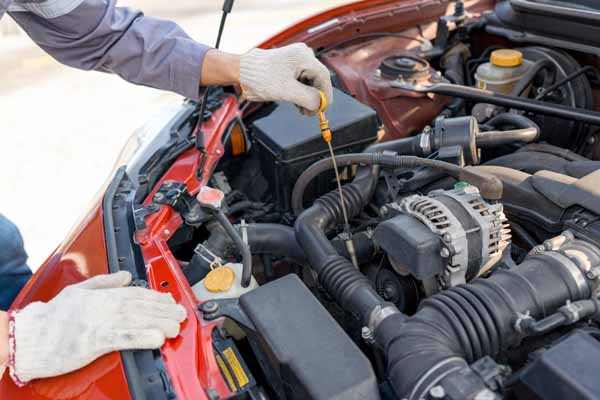 mechanic wearing gloves checking the car